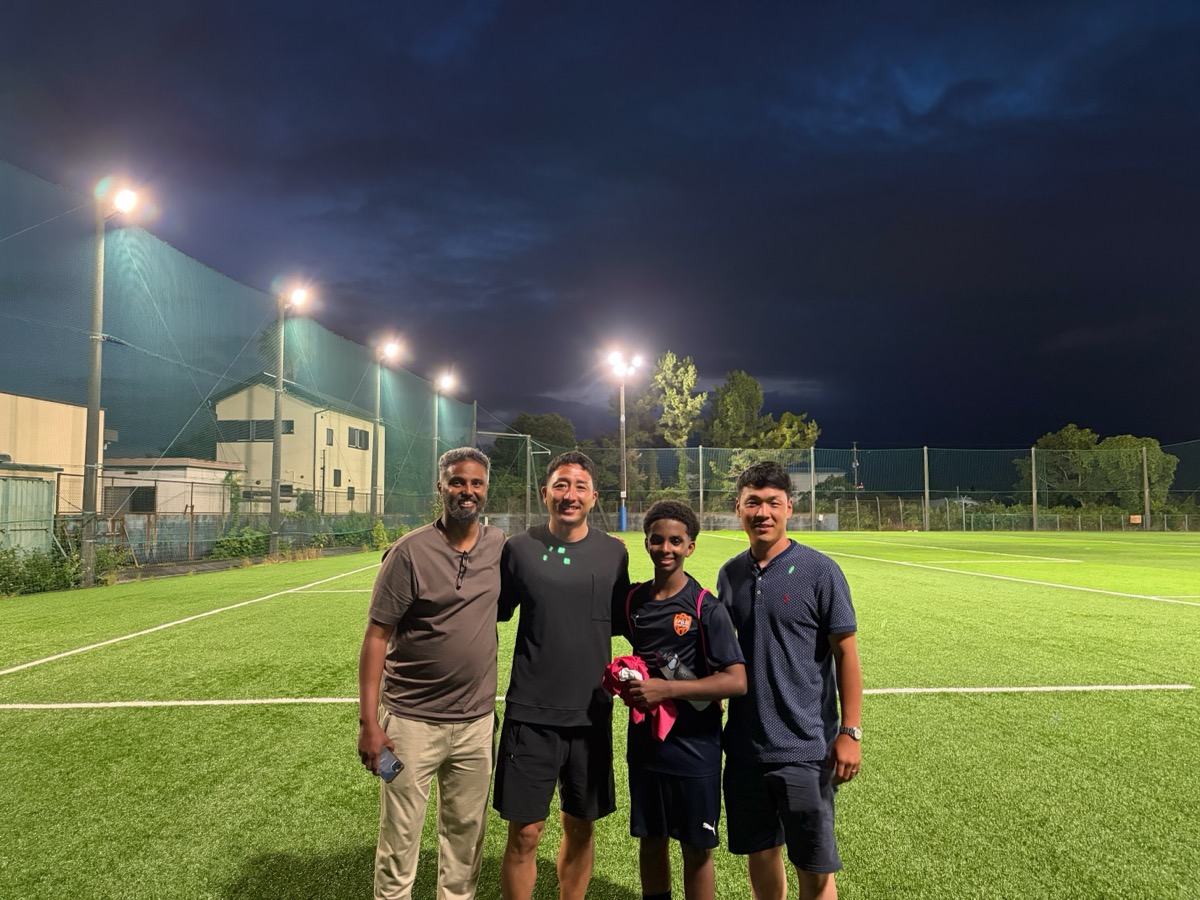 Group photo on the pitch under floodlights after training