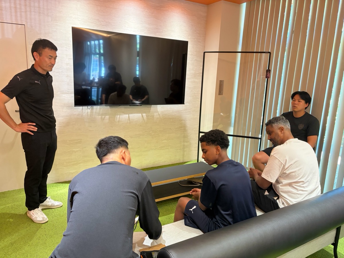 Meeting room discussion with staff, players, and parents